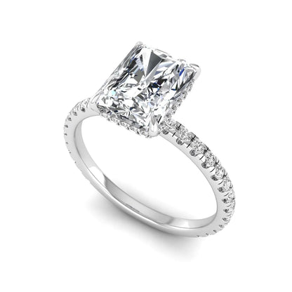 Radiant cut lab grown diamond hidden halo engagement ring featuring a four prong setting, pavé round diamonds, and white gold tone design.
