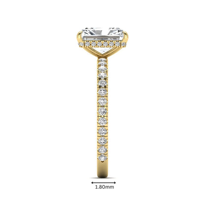 Radiant cut lab grown diamond hidden halo engagement ring featuring a four prong setting, pavé round diamonds, and yellow gold tone design.