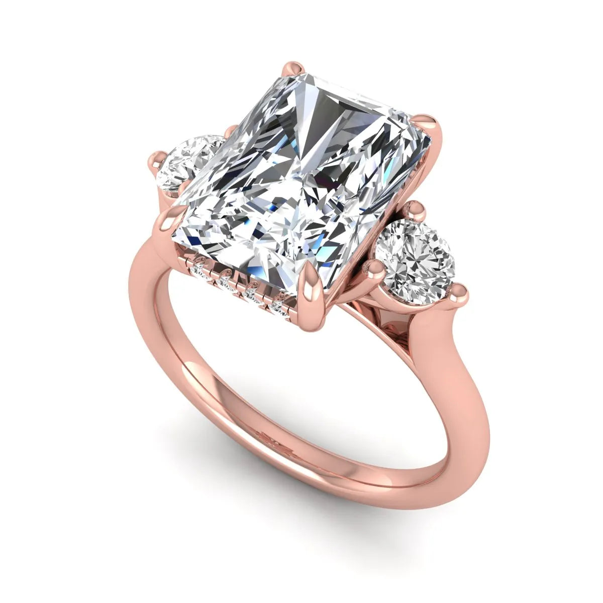 Radiant cut lab grown diamond three stone engagement ring with round side diamonds in a four-prong setting and rose gold tone band.