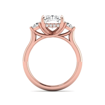 Radiant cut lab grown diamond three stone engagement ring with round side diamonds in a four-prong setting and rose gold tone band.
