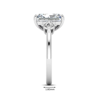 Radiant cut lab grown diamond three stone engagement ring with round side diamonds in a four-prong setting and white gold tone band.