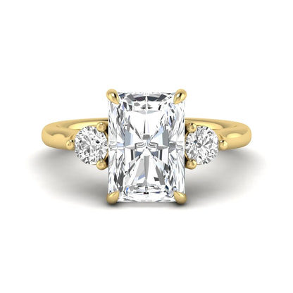 Radiant cut lab grown diamond three stone engagement ring with round side diamonds in a four-prong setting and yellow gold tone band.
