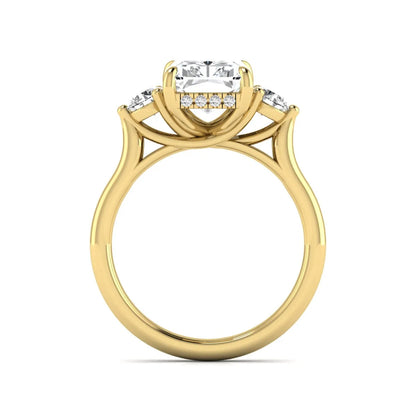 Radiant cut lab grown diamond three stone engagement ring with round side diamonds in a four-prong setting and yellow gold tone band.