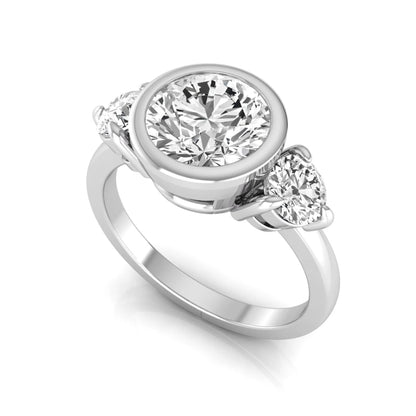 Round cut lab grown diamond three stone engagement ring with a bezel set center diamond and round side diamonds in white gold
