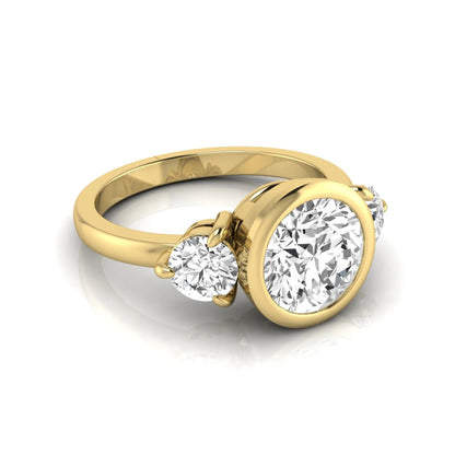 Round cut lab grown diamond three stone engagement ring with a bezel set center diamond and round side diamonds in yellow gold
