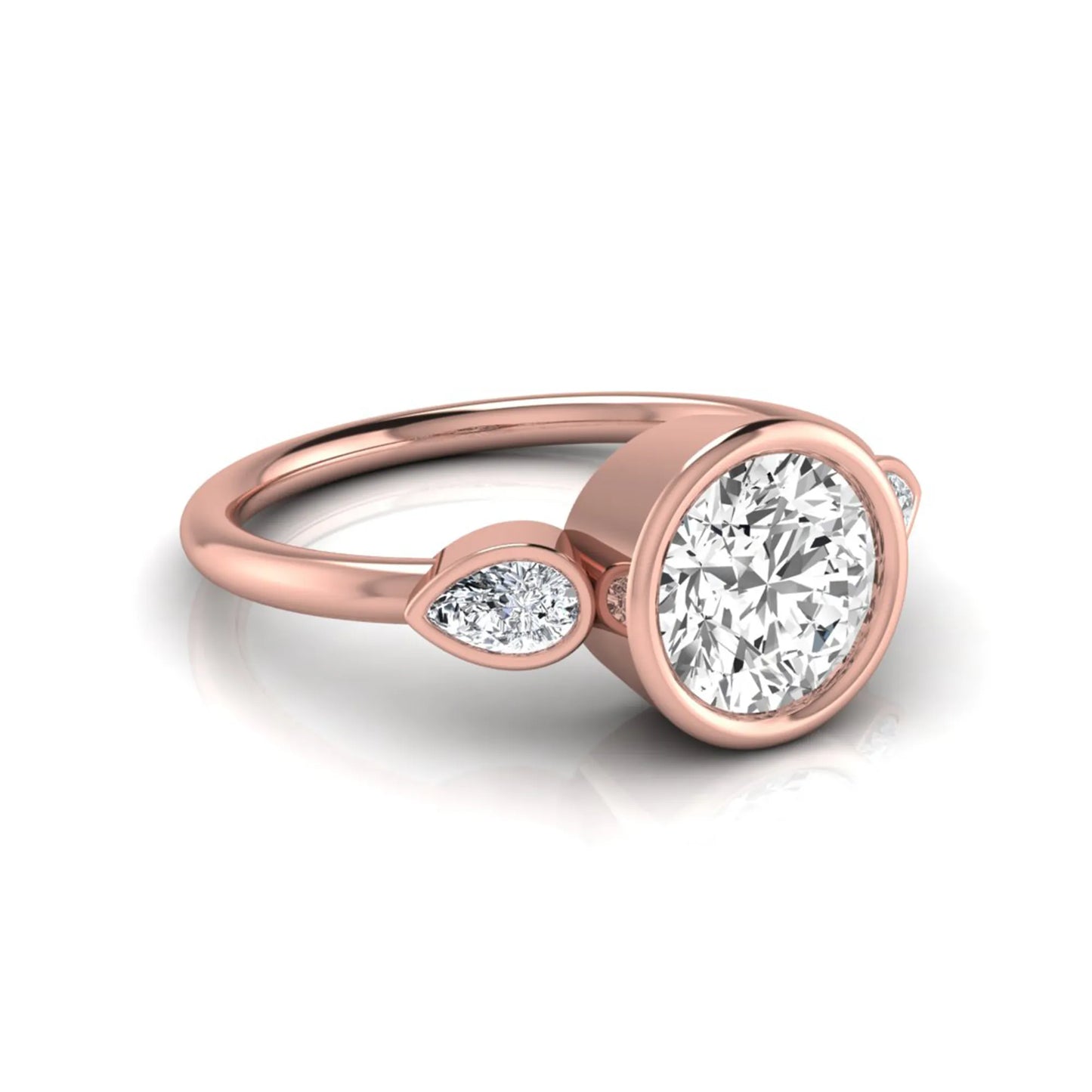 Round cut lab grown diamond bezel three stone engagement ring featuring a 1.28 carat IGI certified center diamond with pear cut side diamonds in rose gold.