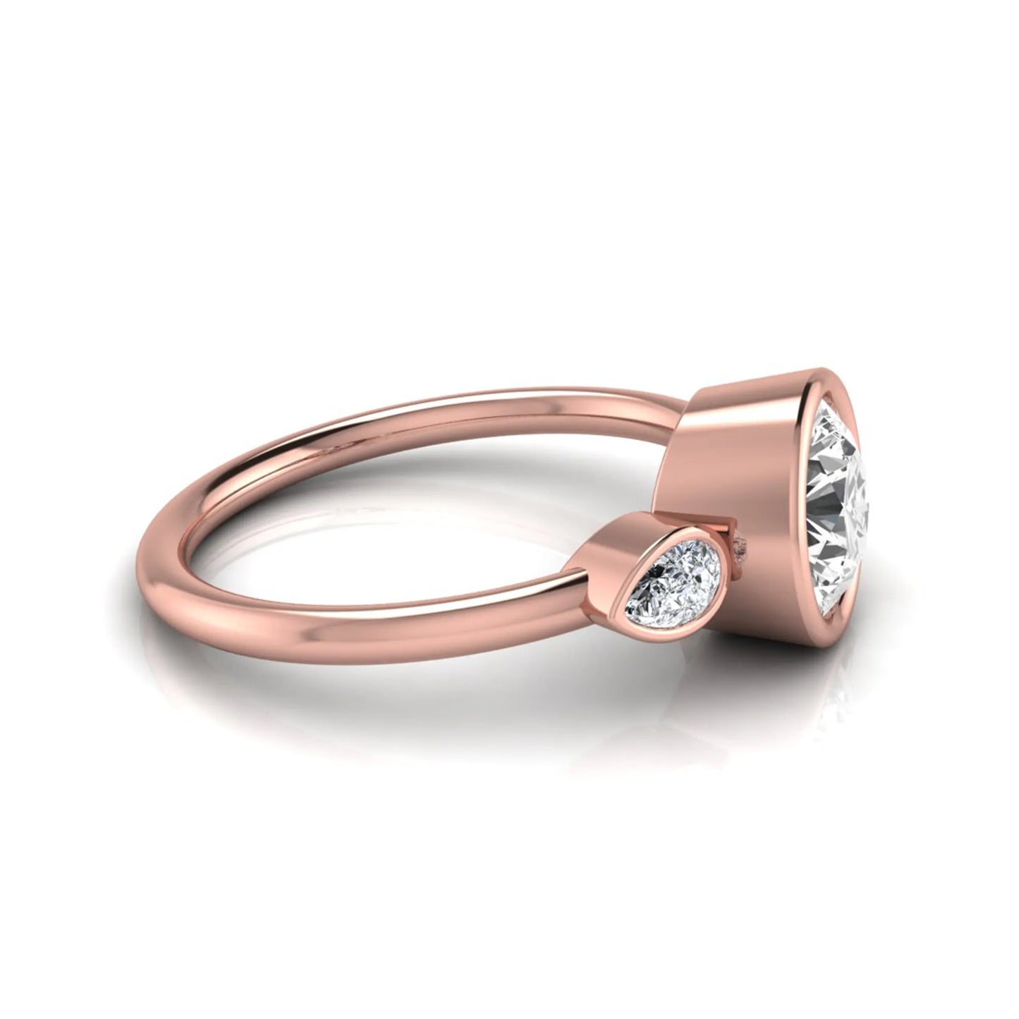 Round cut lab grown diamond bezel three stone engagement ring featuring a 1.28 carat IGI certified center diamond with pear cut side diamonds in rose gold.