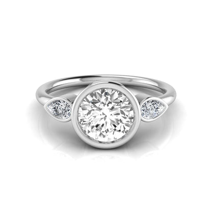 Round cut lab grown diamond bezel three stone engagement ring featuring a 1.28 carat IGI certified center diamond with pear cut side diamonds in white gold.