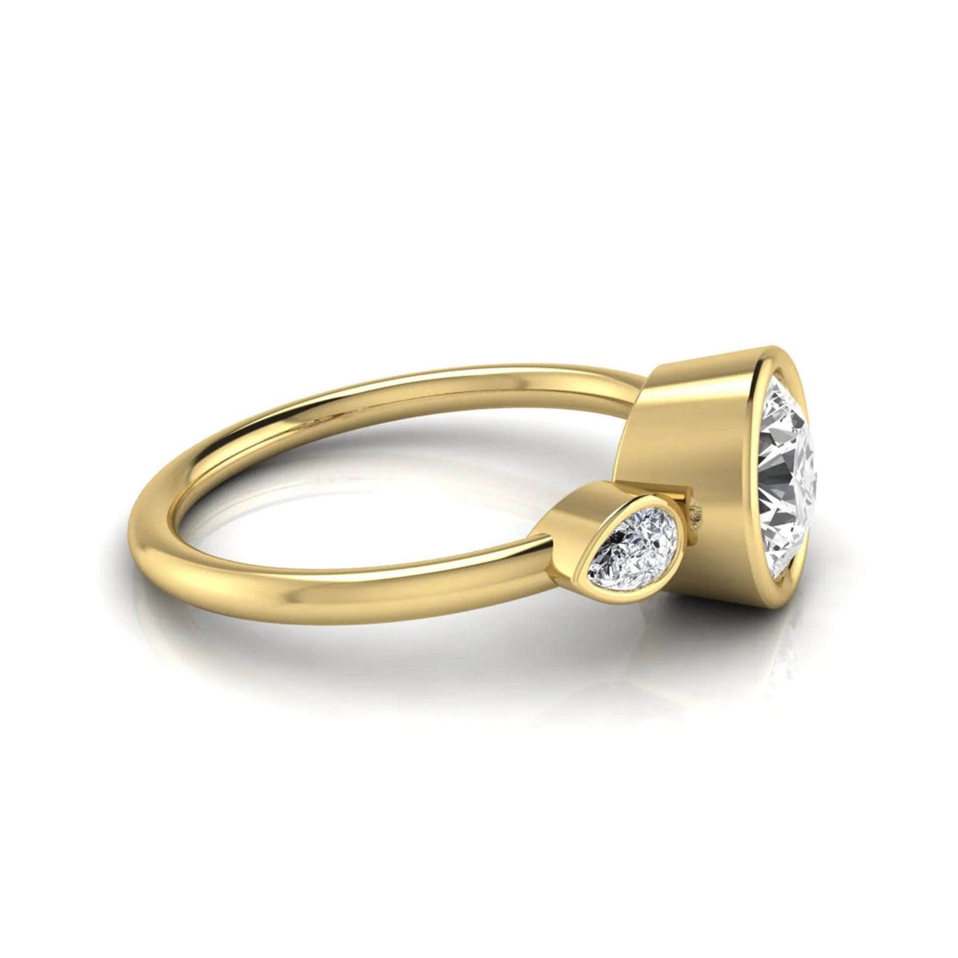Round cut lab grown diamond bezel three stone engagement ring featuring a 1.28 carat IGI certified center diamond with pear cut side diamonds in yellow gold.