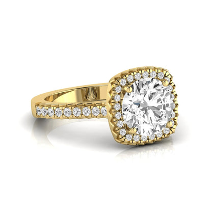Round cut lab grown diamond halo engagement ring featuring a four-prong center setting with a pavé diamond band in yellow gold tone.