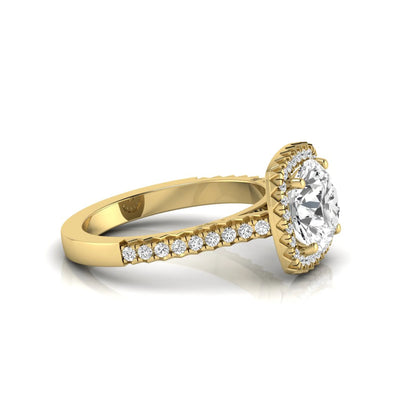 Round cut lab grown diamond halo engagement ring featuring a four-prong center setting with a pavé diamond band in yellow gold tone.