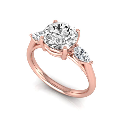 Round cut lab grown diamond three stone engagement ring featuring a 2.04 carat IGI certified center diamond with pear side diamonds in rose gold
