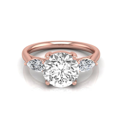 Round cut lab grown diamond three stone engagement ring featuring a 2.04 carat IGI certified center diamond with pear side diamonds in rose gold