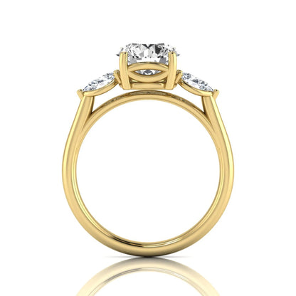 Round cut lab grown diamond three stone engagement ring featuring a 2.04 carat IGI certified center diamond with pear side diamonds in yellow gold
