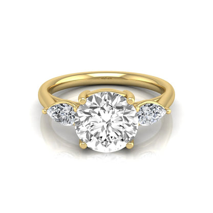 Round cut lab grown diamond three stone engagement ring featuring a 2.04 carat IGI certified center diamond with pear side diamonds in yellow gold