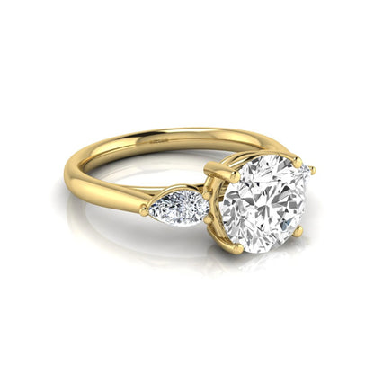 Round cut lab grown diamond three stone engagement ring featuring a 2.04 carat IGI certified center diamond with pear side diamonds in yellow gold