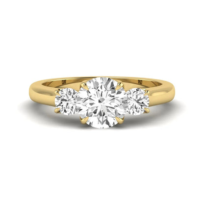 IGI certified round cut lab grown diamond three stone engagement ring with round side diamonds in yellow gold.