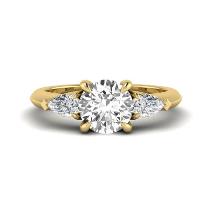 IGI certified round cut lab grown diamond three stone engagement ring with pear side diamonds in yellow gold.
