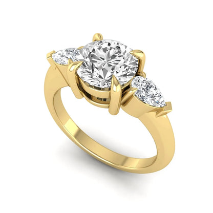 IGI certified round cut lab grown diamond three stone engagement ring with pear side diamonds in yellow gold.