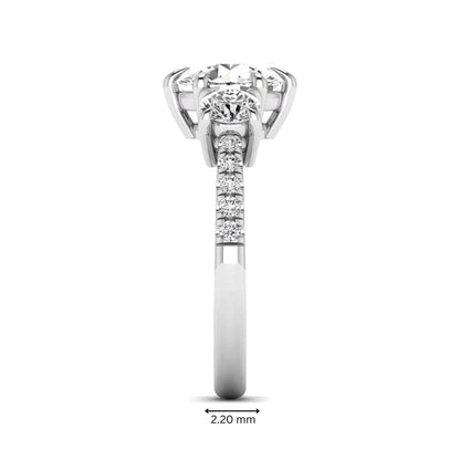 Round cut lab grown diamond three stone engagement ring with two round side diamonds and diamond accented shoulders in white gold