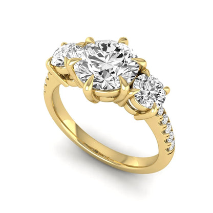 Round cut lab grown diamond three stone engagement ring with two round side diamonds and diamond accented shoulders in yellow gold