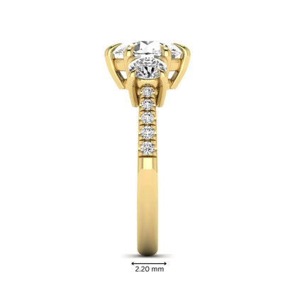 Round cut lab grown diamond three stone engagement ring with two round side diamonds and diamond accented shoulders in yellow gold
