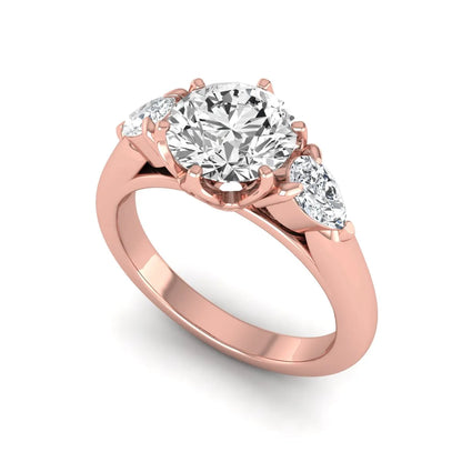 Round cut lab grown diamond three stone engagement ring with pear side diamonds in rose gold.