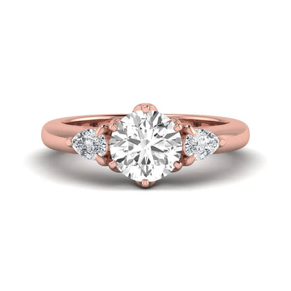 Round cut lab grown diamond three stone engagement ring with pear side diamonds in rose gold.