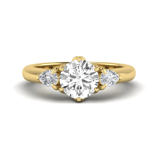 Round cut lab grown diamond three stone engagement ring with pear side diamonds in yellow gold.