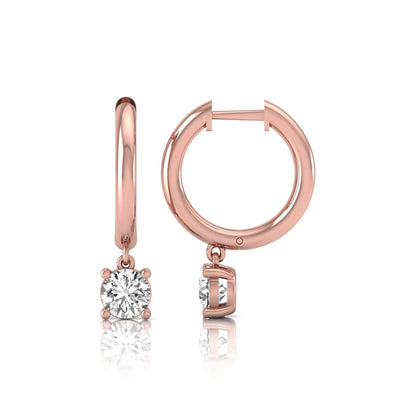 Round cut lab grown diamond drop huggie hoop earrings featuring a four prong drop setting, hinged snap closure, and polished rose gold tone finish.