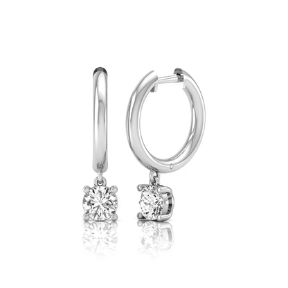 Round cut lab grown diamond drop huggie hoop earrings featuring a four prong drop setting, hinged snap closure, and polished white gold tone finish.