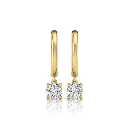 Round cut lab grown diamond drop huggie hoop earrings featuring a four prong drop setting, hinged snap closure, and polished yellow gold tone finish.
