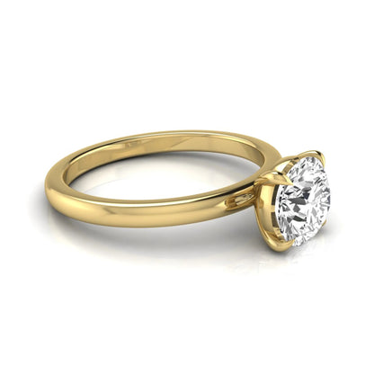 Round cut lab grown diamond solitaire engagement ring featuring a classic four-prong setting with a yellow gold tone band.