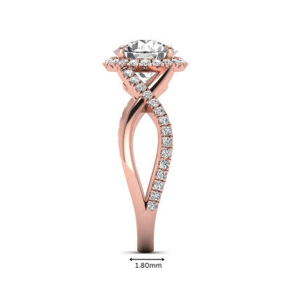 Round cut lab grown diamond halo engagement ring featuring a bypass split shank with pavé round diamonds in a rose gold tone design.