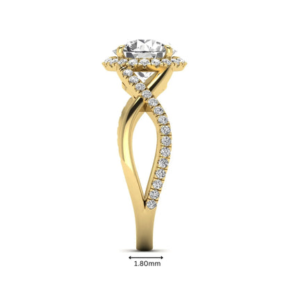 Round cut lab grown diamond halo engagement ring featuring a bypass split shank with pavé round diamonds in a yellow gold tone design.