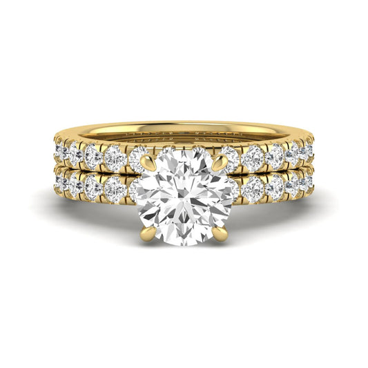 Round cut lab grown diamond bridal ring set in yellow gold featuring a 1.67 carat IGI certified center diamond with matching diamond wedding band.