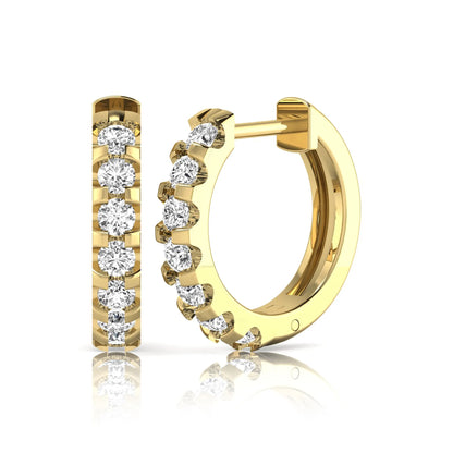 Round lab grown diamond half eternity huggie hoop earrings featuring a continuous row of round brilliant diamonds in a shared prong setting in yellow gold