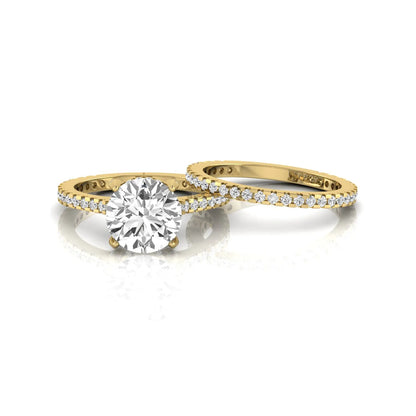 Round cut lab grown diamond bridal ring set featuring an IGI certified center diamond with matching pavé diamond wedding band in a classic four-prong setting in yellow gold