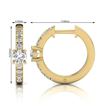 Round brilliant lab grown diamond pavé huggie hoop earrings featuring a four prong center diamond with graduated shared prong pavé round diamonds in yellow gold.