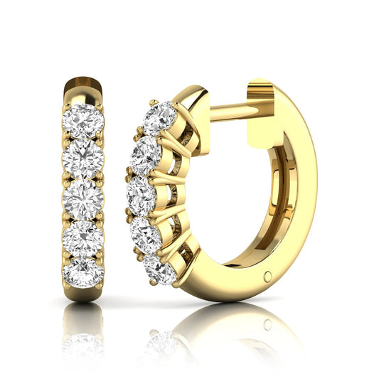 Round cut lab grown diamond front-facing huggie hoop earrings featuring a shared four prong setting, hinged snap closure, and polished yellow gold finish.