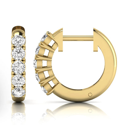 Round cut lab grown diamond front-facing huggie hoop earrings featuring a shared four prong setting, hinged snap closure, and polished yellow gold finish.