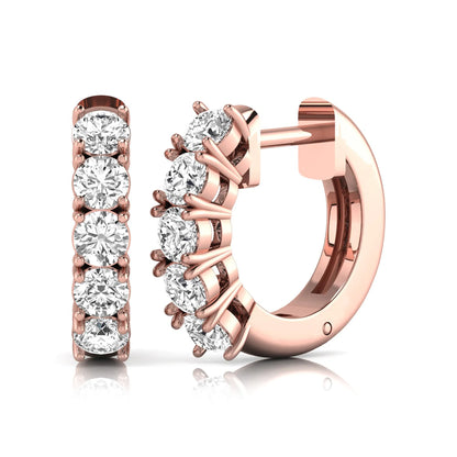 Round cut lab grown diamond huggie hoop earrings featuring five front-facing diamonds in a shared four prong setting with a hinged snap closure and polished rose gold finish.