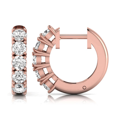 Round cut lab grown diamond huggie hoop earrings featuring five front-facing diamonds in a shared four prong setting with a hinged snap closure and polished rose gold finish.