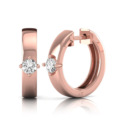 Round cut lab grown diamond huggie hoop earrings featuring a four prong setting and hinged snap closure shown in rose gold tone with a polished finish.