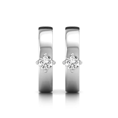 Round cut lab grown diamond huggie hoop earrings featuring a four prong setting and hinged snap closure shown in white gold tone with a polished finish.
