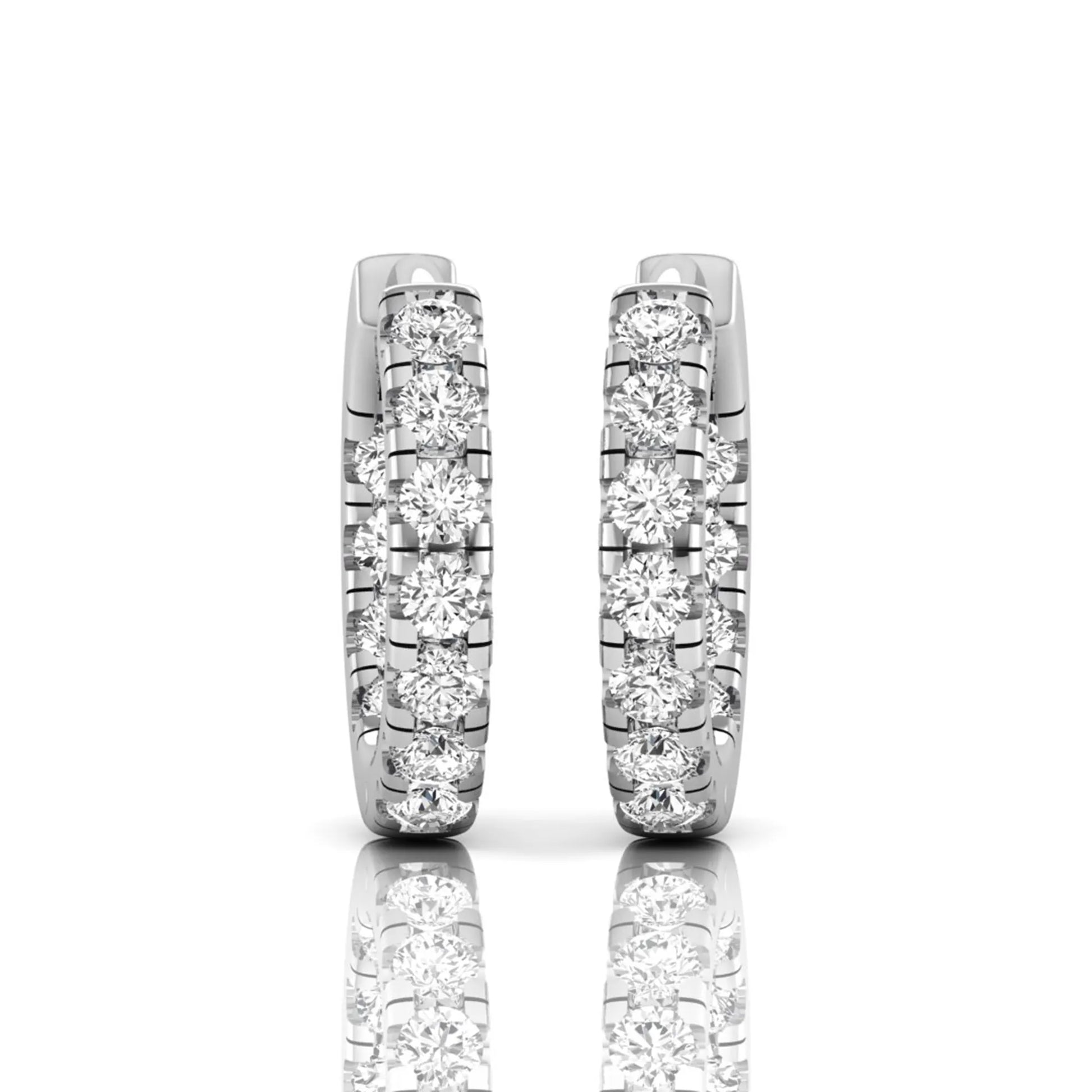 Round prong set lab grown diamond huggie hoop earrings featuring round cut diamonds in a classic hinged hoop design with white gold tone shown for display.