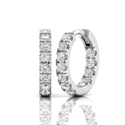 Round prong set lab grown diamond huggie hoop earrings featuring round cut diamonds in a classic hinged hoop design with white gold tone shown for display.
