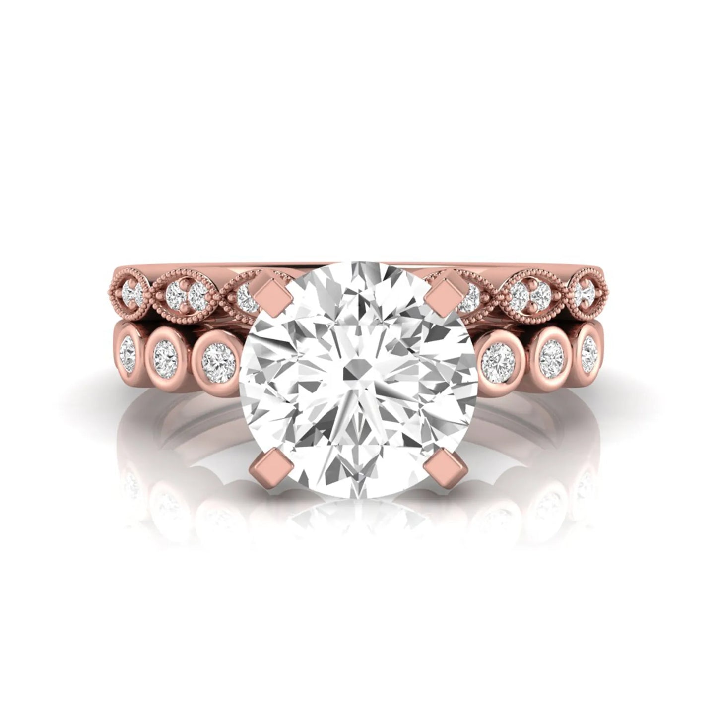 Round cut lab grown diamond bridal ring set featuring a four-prong solitaire engagement ring with a matching side stone wedding band accented by round bezel-set diamonds and vintage milgrain detailing in rose gold