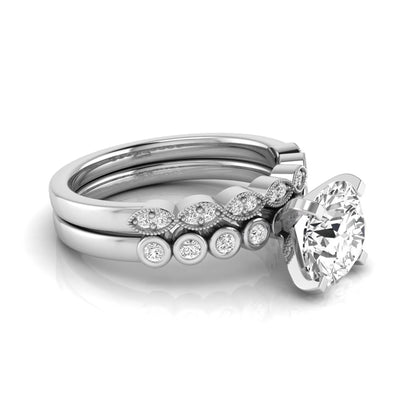 Round cut lab grown diamond bridal ring set featuring a four-prong solitaire engagement ring with a matching side stone wedding band accented by round bezel-set diamonds and vintage milgrain detailing.