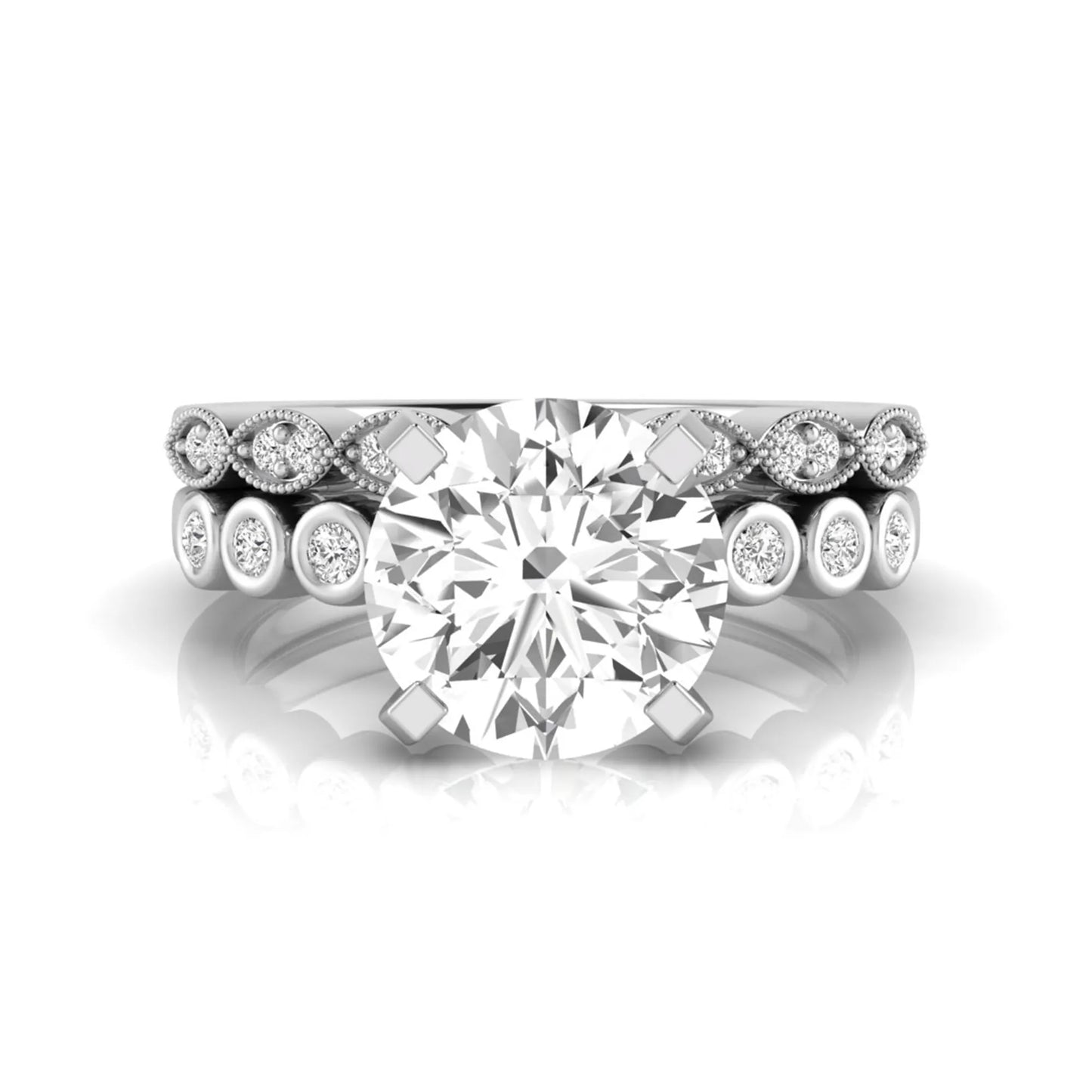 Round cut lab grown diamond bridal ring set featuring a four-prong solitaire engagement ring with a matching side stone wedding band accented by round bezel-set diamonds and vintage milgrain detailing in white gold